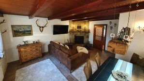 Una sala de estar acogedora con chimenea, muebles de madera y una pared de piedra.