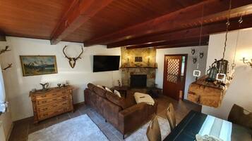 Ein gemütliches Wohnzimmer mit Kamin, Holzmöbeln und einer Steinwand.