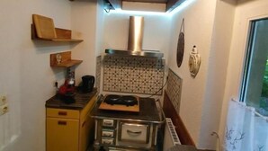A compact kitchen with a stove, a sink, and a window.