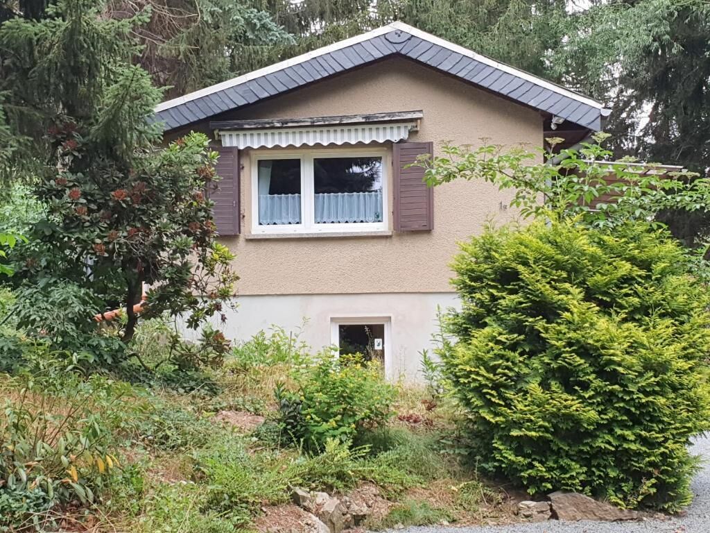 Una casa de dos pisos con techo a dos aguas, un pequeño porche y una ventana con contraventanas.
