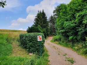 A rural dirt path with a sign indicating a wildlife crossing.