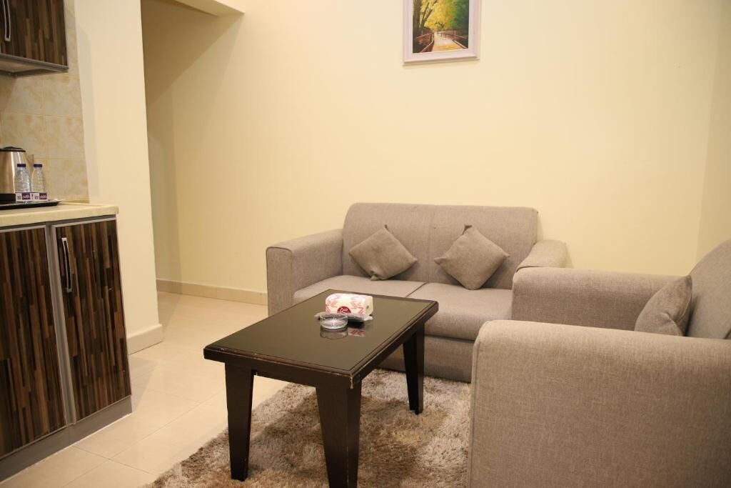 Una sala de estar con un sofá, una mesa de centro y un aparador.