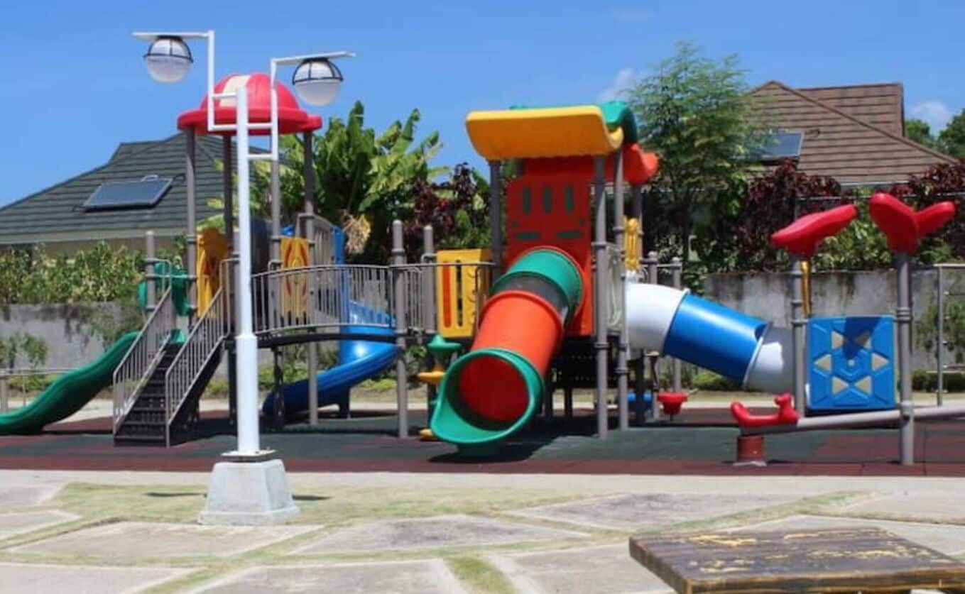 A playground with various play structures including slides and climbing elements.