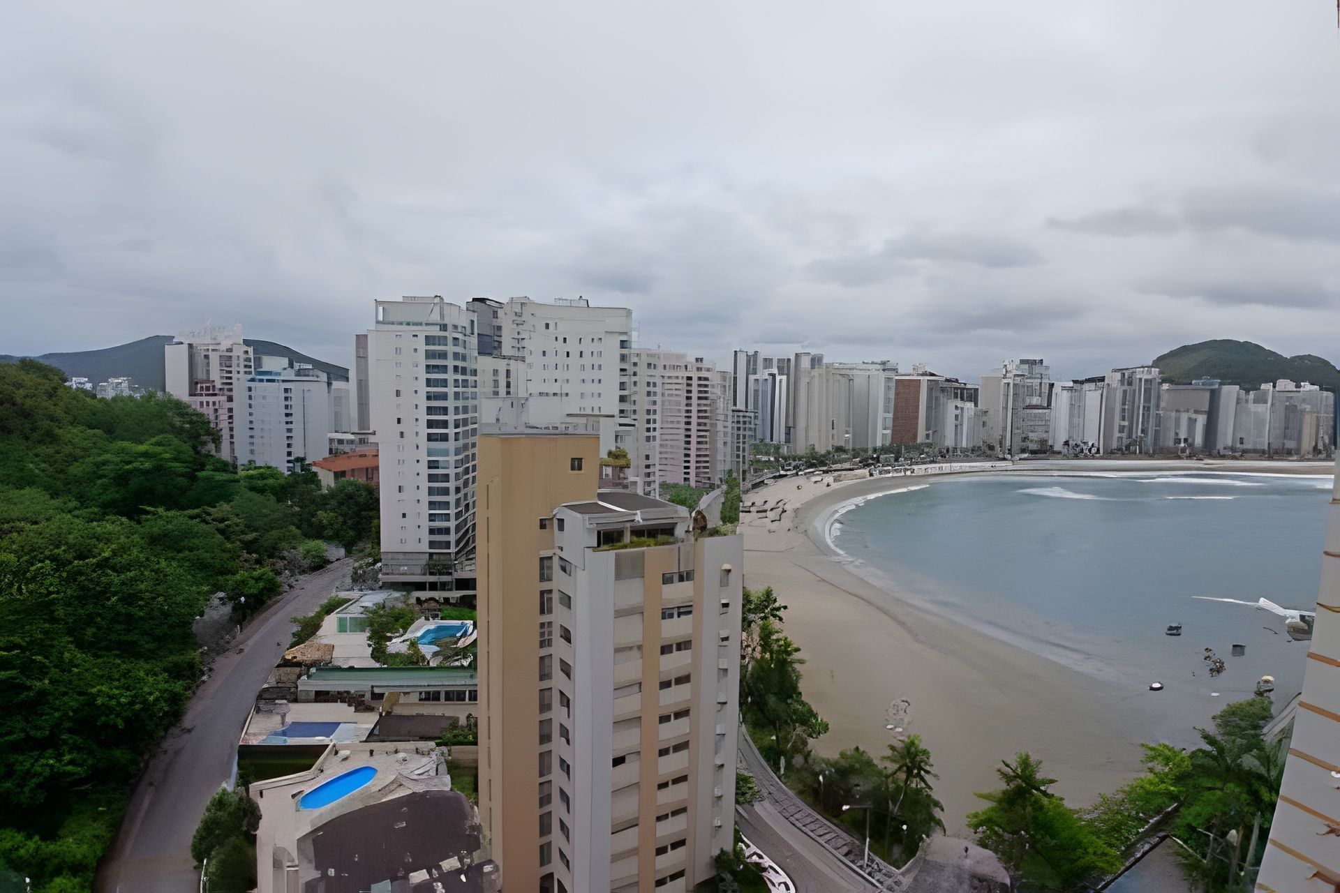 Un paisaje urbano costero con edificios altos, una playa y una zona de piscina.