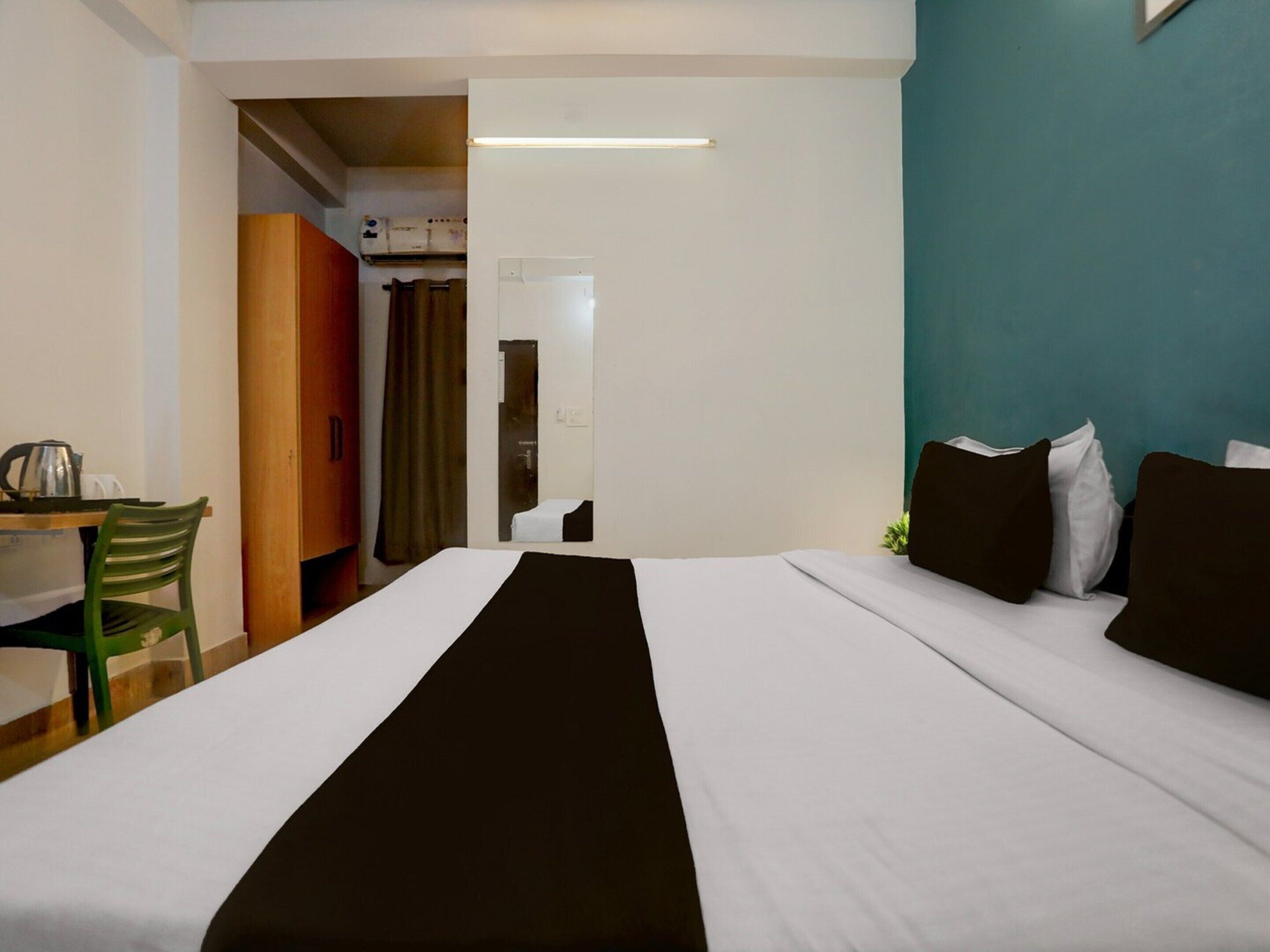 A hotel room with a bed, a desk, and a chair.