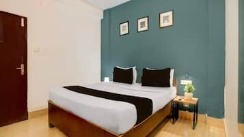 Ein Hotelzimmer mit einem Bett, einem Nachttisch, einer Lampe und einer Tür.