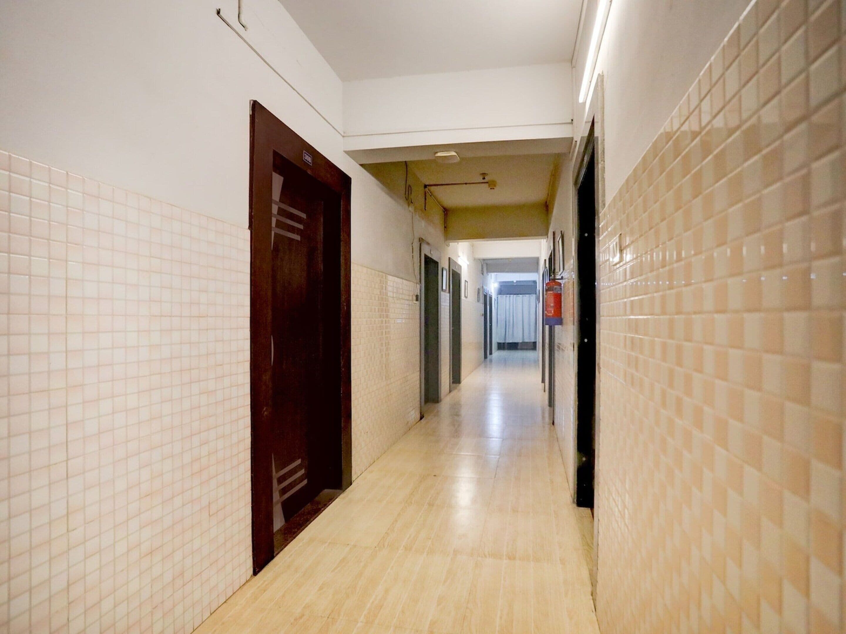 Un corridoio con pareti piastrellate e una porta in legno.