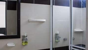 Un baño con inodoro, lavamanos y cabina de ducha de vidrio.