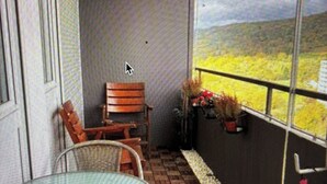 A covered patio with a table and chairs, a bench, and potted plants. - Stylish flat close to Basel with a stunning view (Weil am Rhein)