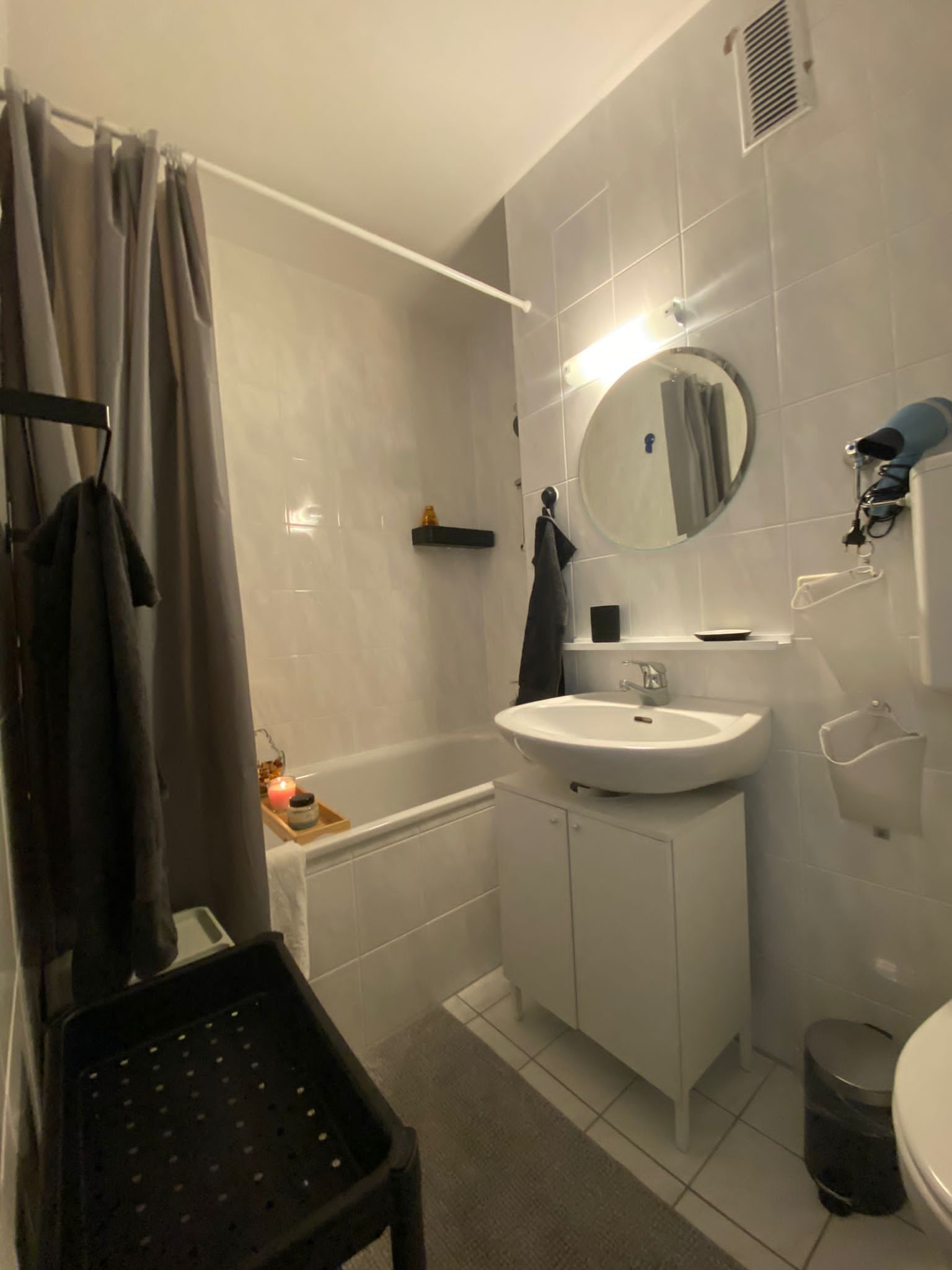 A modern bathroom with a bathtub, a sink, a mirror, and a toilet.