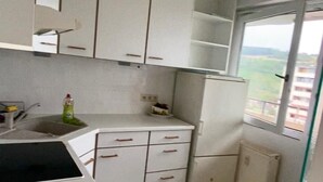 A kitchen with white cabinets, a sink, and a window with a view. - Stylish flat close to Basel with a stunning view (Weil am Rhein)