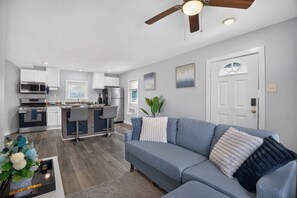 A modern kitchen with white cabinets, a built-in oven, and a stainless steel refrigerator. - Blue Luxe Getaway Stylish 2BR Near Downtown (Houston)