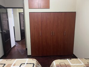 A room with a large wardrobe, a bed with patterned bedding, and a hallway leading to another room. - Awesome 3-bedroom apartment in welcoming Lince neighborhood (Lince)