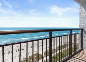 Ein Balkon mit Blick auf Strand und Meer.