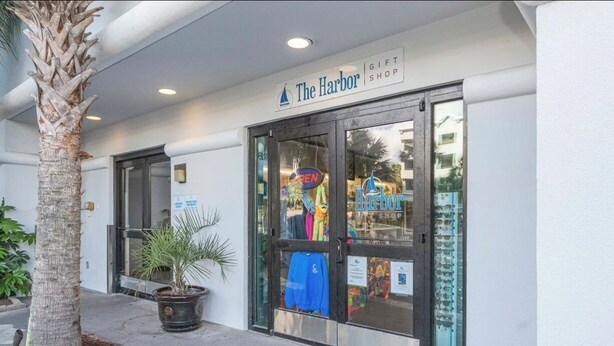A storefront with a sign reading 'The Harbor Gift Shop' and a palm tree in front. - Oceanfront Paradise Getaway (Myrtle Beach)