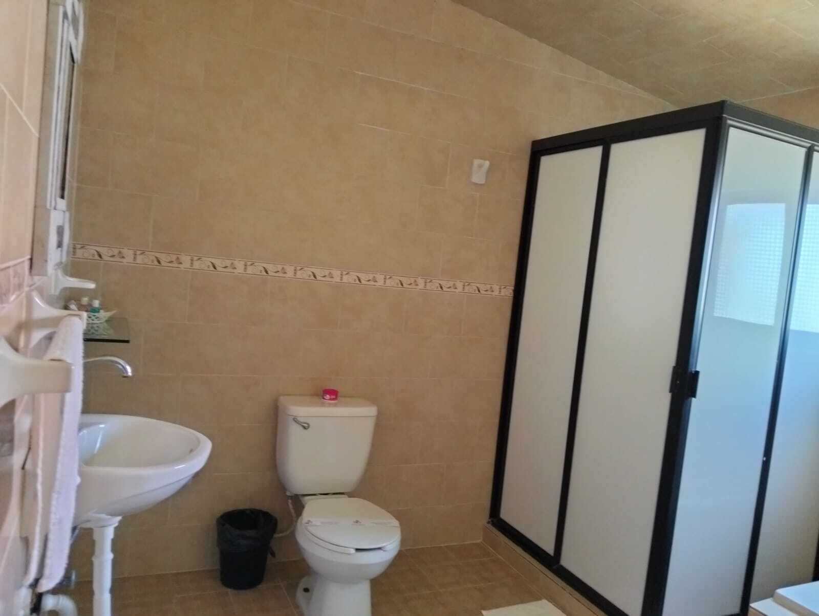Un baño con inodoro, lavabo y un basurero.