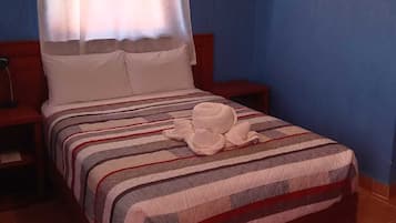 Una cama con colcha a rayas, un almohadón blanco y un dosel blanco.
