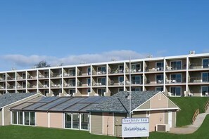 A multi-story hotel with a sign for Surfside Inn and a building with a sloped roof.