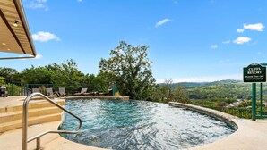 Ein Pool mit Blick auf die Berge, ein Schild für Cliff's Resort und Außenbereich-Sitzgelegenheiten.