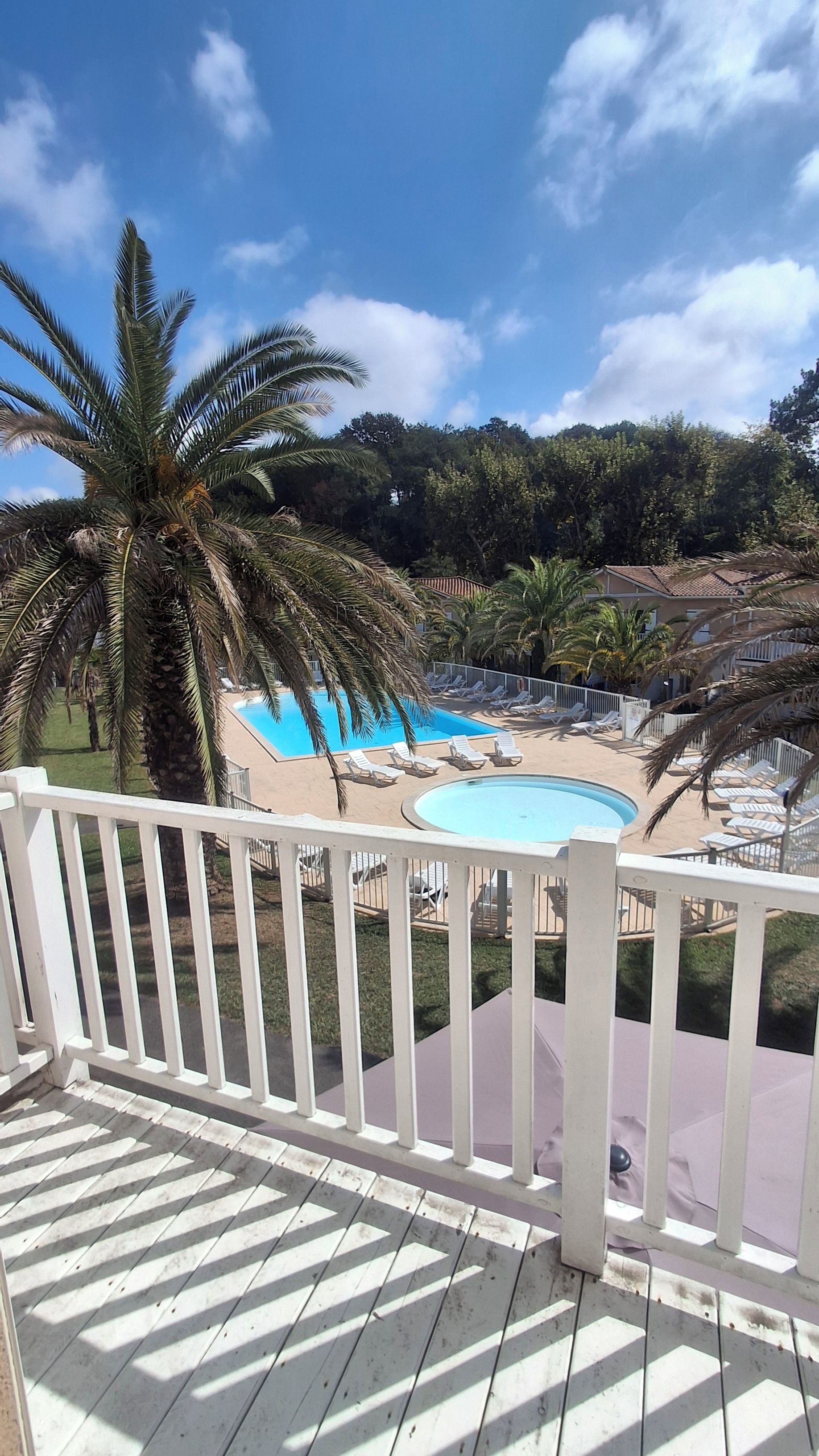 A pool area with lounge chairs and a wooden deck.