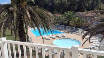 A pool area with lounge chairs and a wooden deck.
