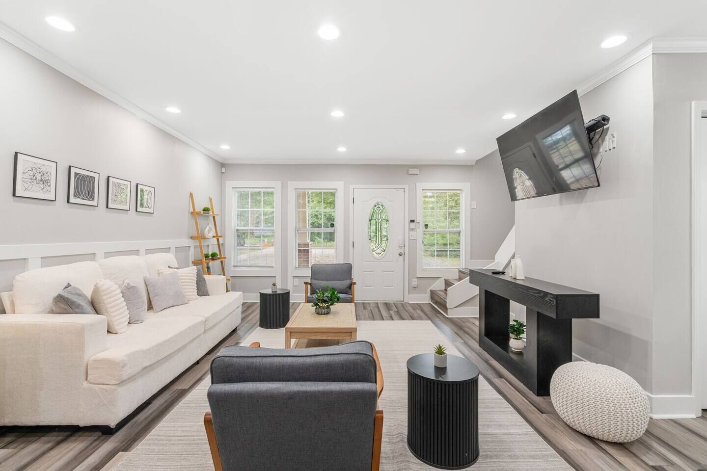 A modern living room with a sofa, armchairs, a coffee table, and a fireplace.