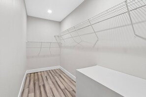 Una habitación con techo blanco, suelo de madera y un banco blanco.
