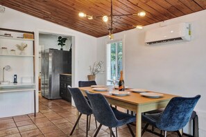 A dining area with a wooden table, chairs, and a bottle of champagne. - Sunny Regards Retreat (Fort Lauderdale)