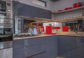 Eine moderne Küche mit Edelstahlgeräten, einem Backofen und einer Dunstabzugshaube.