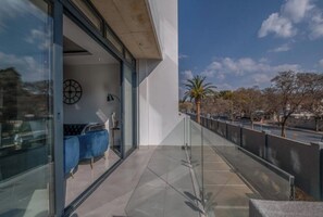 Ein modernes Gebäude mit Glastür, einer Uhr an der Wand und einem blauen Stuhl davor.