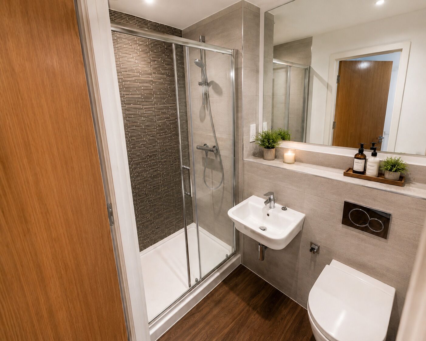 A modern bathroom with a glass-enclosed shower, a white sink, and a toilet.