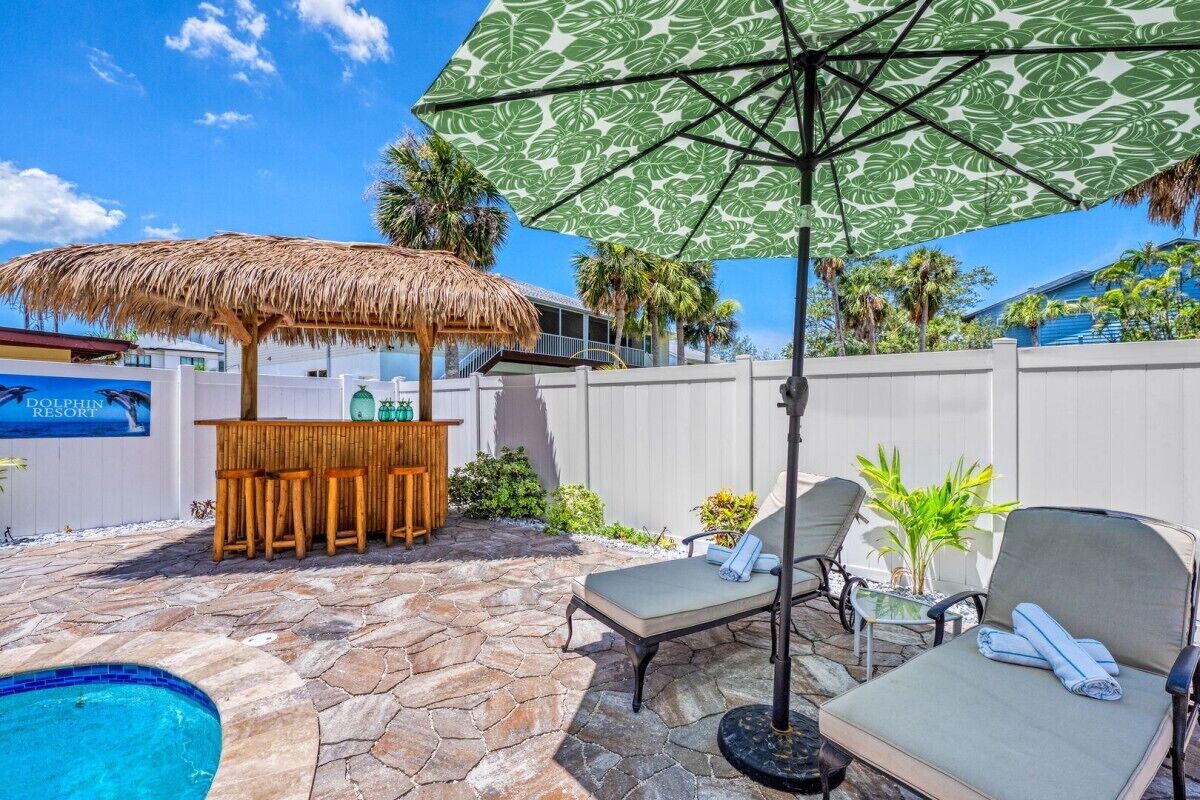 A poolside area with a bar, lounge chairs, and a thatched umbrella.