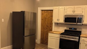 A kitchen with a stainless steel refrigerator, a microwave, and a stove.