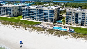 Hotel aan het strand met meerdere gebouwen, een zwembad en een strandgedeelte.