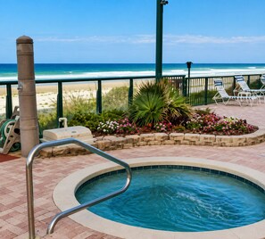 A pool area with a view of the beach, lounge chairs, and a palm tree. - Your Beachfront Escap: Spacious 3 Bedroom 2 bath Condo in Ponce Inlet, Florida (Ponce Inlet)
