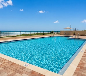 A rectangular swimming pool with clear blue water, surrounded by a tiled deck. - Your Beachfront Escap: Spacious 3 Bedroom 2 bath Condo in Ponce Inlet, Florida (Ponce Inlet)