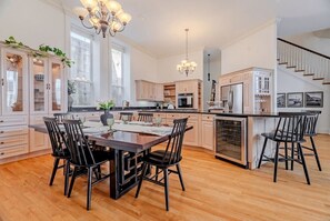 A spacious kitchen with a central island, wooden flooring, and modern appliances.