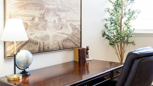 A desk with a globe, books, and a statue, a lamp, and a large framed picture on the wall. - Queens Hall, Historic Luxury in St. John's (St. John's)