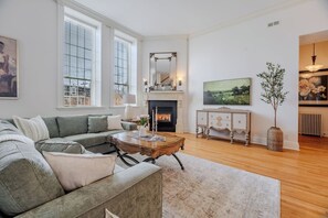 A living room with a fireplace, a sofa, a coffee table, and a television.