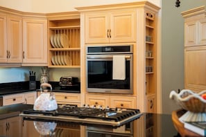 A kitchen with wooden cabinets, a stove, a microwave, and a toaster.
