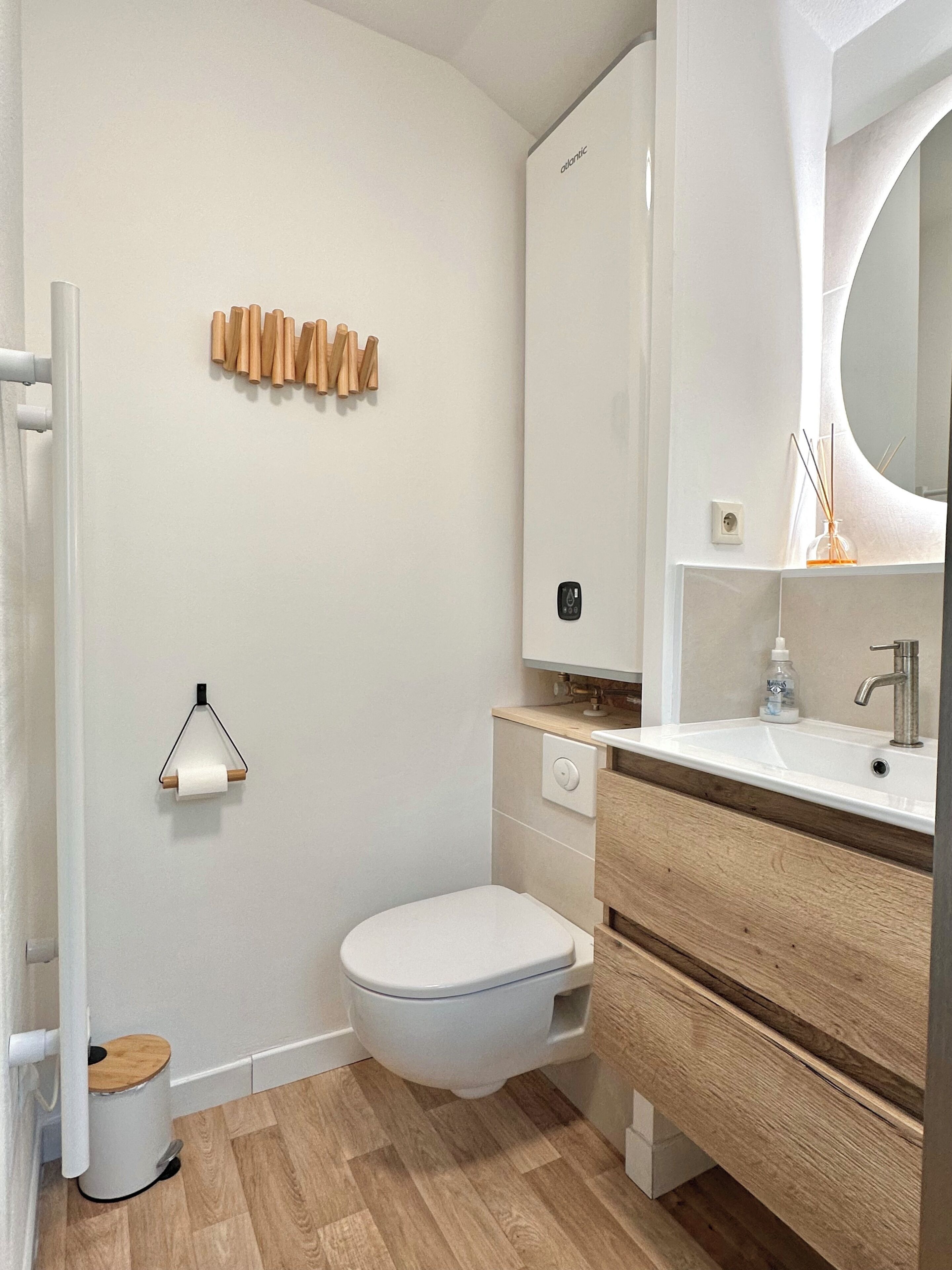 Une salle de bain moderne avec des toilettes, un lavabo et un miroir.
