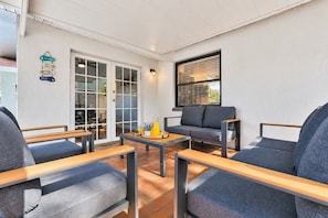 A modern outdoor seating area with a sofa, two armchairs, and a coffee table. - Pool, Fire Pit, Near Beaches | Sleeps 9, Dogs OK (Largo)