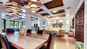 A spacious dining area with a long wooden table, multiple chairs, and a modern pendant light fixture. - Vivara: Private House, PH & 5 Villas-180° Ocean View, Dominical CR  12-Guest (Savegre de Aguirre, Puntarenas Province)
