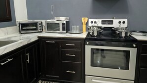 A kitchen with a microwave, toaster, stove, and oven.