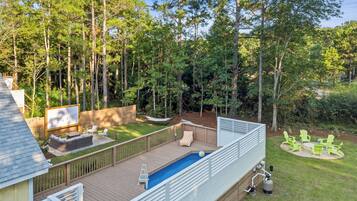 Un jardin avec une piscine, une terrasse et un espace salon extérieur.
