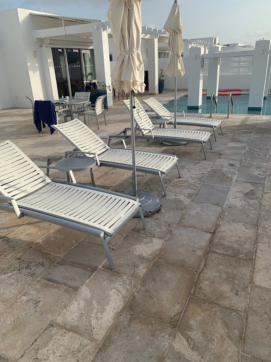 A rooftop pool area with lounge chairs and umbrellas.