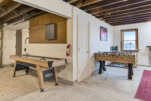 A room with a foosball table, a pool table, and a window with a view. - Seneca Lakefront: Sauna, Hot Tub & Game Room (Penn Yan)