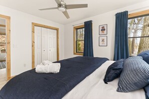 A bedroom with a bed, a ceiling fan, a window with curtains, and a door. - Seneca Lakefront: Sauna, Hot Tub & Game Room (Penn Yan)