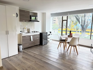 Eine moderne Küche mit Essbereich, großen Fenstern und Blick auf die Straße.