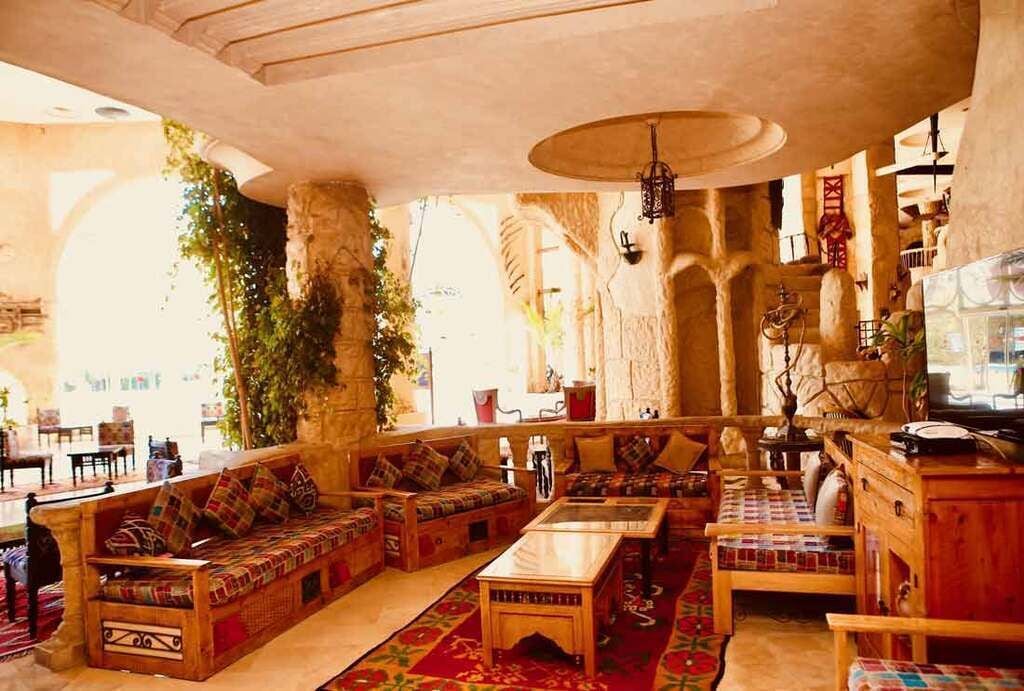 A traditional interior with stone arches, wooden furniture, and a central seating area.
